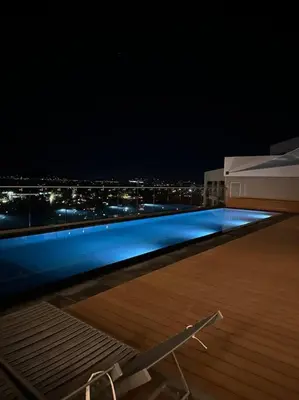 a swimming pool on top of a building at night at Menlyn Maine Golden Sands in Pretoria