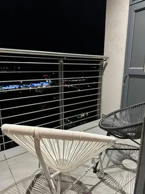 a white chair and a table in front of a window at Menlyn Maine Golden Sands in Pretoria
