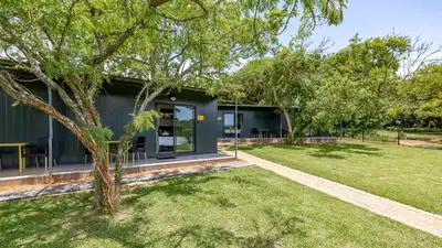 a green house with a tree in the yard at Da Loose Mongoose in White River