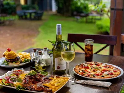 a table with two plates of food and a bottle of wine at Da Loose Mongoose in White River