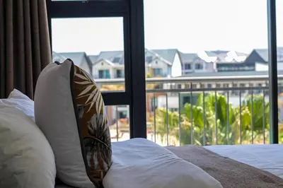 a bed with a pillow and a window with a view at The Blyde Tranquil Escapes in Pretoria