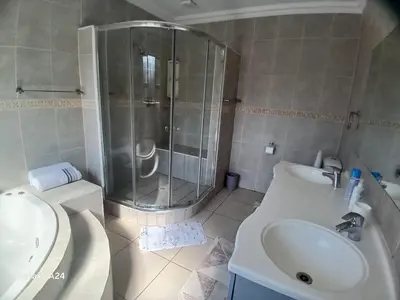 a bathroom with a shower and a sink and a toilet at De Serene B&B in Midrand