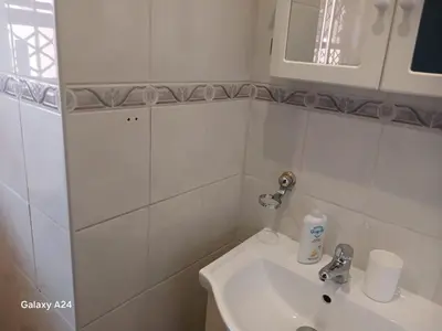a white bathroom with a sink and a mirror at De Serene B&B in Midrand