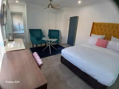 a bedroom with a bed and a table and chairs at De Serene B&B in Midrand