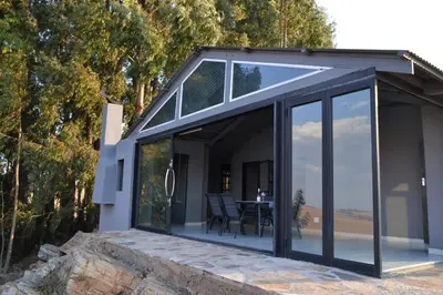 a glass extension of a house with a table at Meadow Mist - Self Catering Unit in Dullstroom