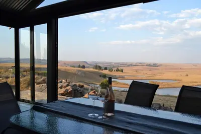 a table with a bottle of wine and a glass at Meadow Mist - Self Catering Unit in Dullstroom