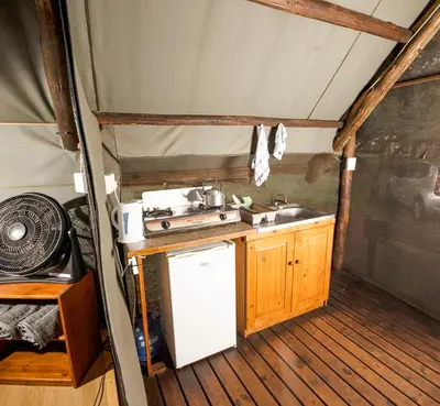 a kitchen with a stove and a sink in a tent at Indabushe Eco Lodge in Schoemanskloof