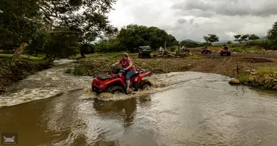 a person riding a quad bike through a river at Indabushe Eco Lodge in Schoemanskloof