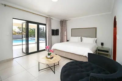 a bedroom with a bed and a couch and a pool at honeymoon suite in Sandton