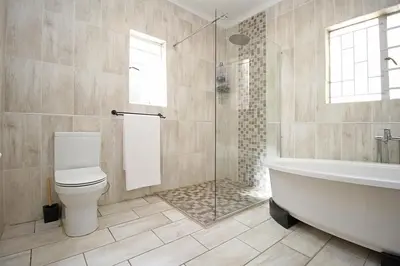 a bathroom with a tub and a toilet and a shower at honeymoon suite in Sandton