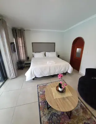 a bedroom with a bed and a coffee table at honeymoon suite in Sandton