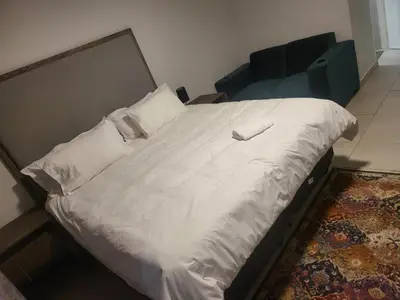 a bed with a white comforter and a pillow at Limewood super Deluxe in Sandton