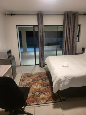 a bedroom with a bed and a large window at Limewood super Deluxe in Sandton