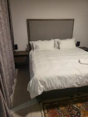 a bed with white sheets and pillows in a room at Limewood super Deluxe in Sandton