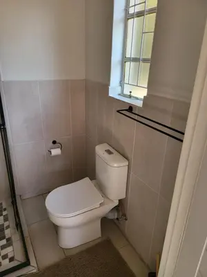 a small bathroom with a toilet and a window at Limewood Vintage in Sandton