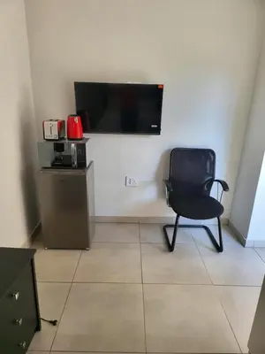 a black chair in a room with a flat screen tv at Limewood Vintage in Sandton