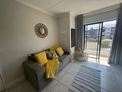 a living room with a couch and a large window at The blyde in Pretoria