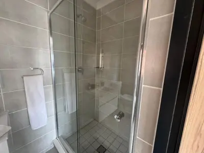 a bathroom shower with a glass shower stall at The blyde in Pretoria