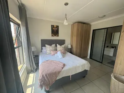 a bedroom with a bed and a large window at The blyde in Pretoria