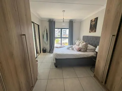 a bedroom with a bed and a large window at The blyde in Pretoria