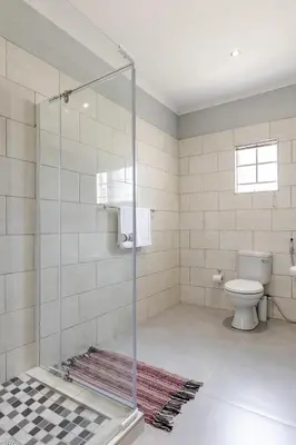 a glass shower in a bathroom with a toilet at Point R40 Lodge - Conference, Self Catering & Spa in Nelspruit