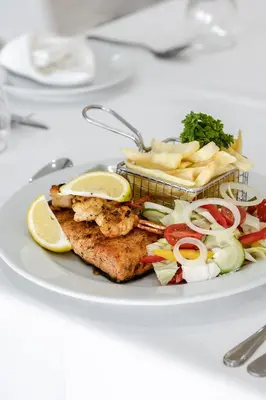 a plate of food with fish and vegetables on a table at Point R40 Lodge - Conference, Self Catering & Spa in Nelspruit