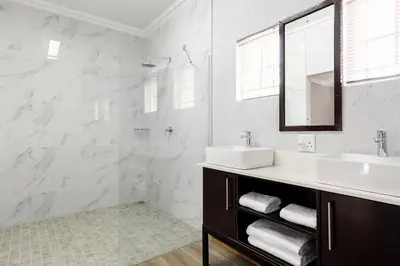 a white bathroom with a sink and a mirror at Point R40 Lodge - Conference, Self Catering & Spa in Nelspruit