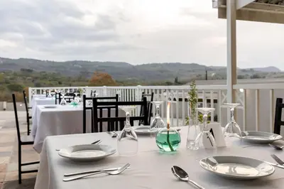 a table with white plates and silverware on a balcony at Point R40 Lodge - Conference, Self Catering & Spa in Nelspruit