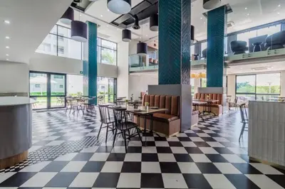 a restaurant with tables and chairs on a checkered floor at Lovely 1 Bedroom Apartment in Pretoria
