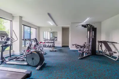 a gym with several treadmills and exercise bikes at Lovely 1 Bedroom Apartment in Pretoria