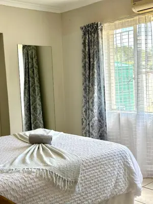 a bedroom with a white bed and a window at Guesthouse 52 in Groblersdal