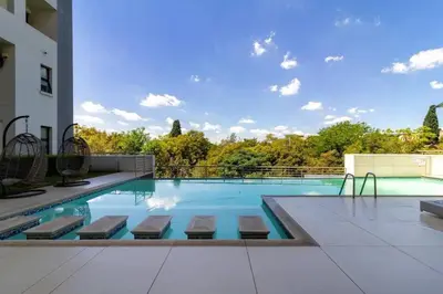 a swimming pool with a view of a building at 1 bedroom Apartment in Pretoria