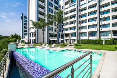a swimming pool in front of a building at 1 bedroom Apartment in Pretoria
