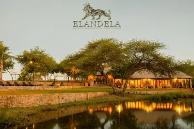 a building with a zebra sign next to a river at Elandela Private Game Reserve and Luxury Lodges Pty Ltd in Hoedspruit