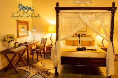 a bedroom with a canopy bed with a desk and a desk at Elandela Private Game Reserve and Luxury Lodges Pty Ltd in Hoedspruit