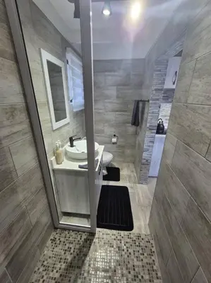 a bathroom with a sink and a shower with a mirror at Edel's Nest Nelspruit in Mataffin