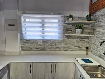 a kitchen with a sink and a window with blinds at Edel's Nest Nelspruit in Mataffin