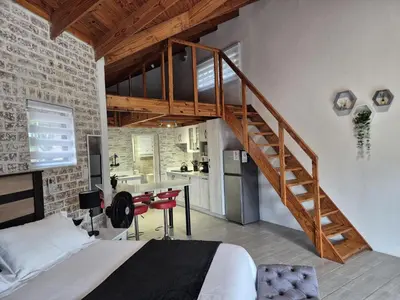 a bedroom with a loft bed and a staircase at Edel's Nest Nelspruit in Mataffin