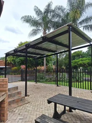a pavilion with a picnic bench in front of a fence at Edel's Nest Nelspruit in Mataffin