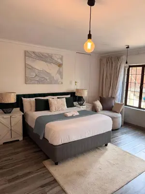 a bedroom with a large bed and a couch at Cozy Urban Oasis in Hatfield in Pretoria
