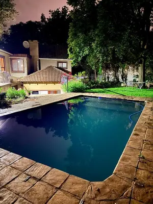 a swimming pool in front of a house at Cozy Urban Oasis in Hatfield in Pretoria