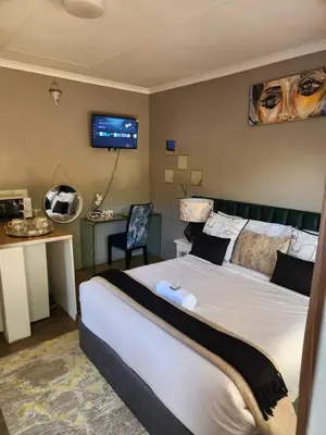 a bedroom with a bed and a tv on the wall at Cozy Urban Oasis in Hatfield in Pretoria