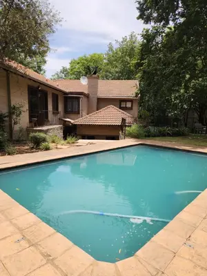 a swimming pool in front of a house at Cozy Urban Oasis in Hatfield in Pretoria