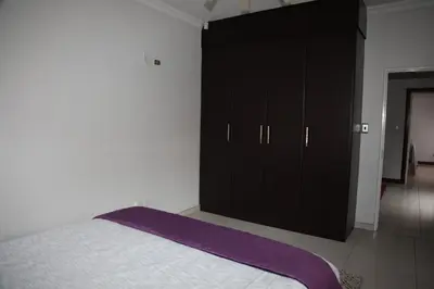 a bedroom with a bed and a black cabinet at Guest Home KS2E - Self Catering in Kempton Park