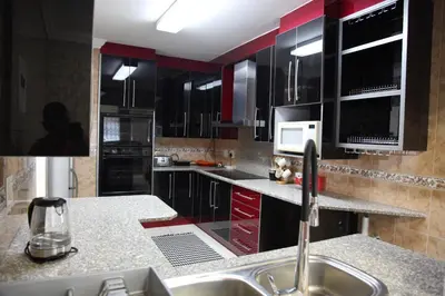 a kitchen with black and red cabinets and a sink at Guest Home KS2E - Self Catering in Kempton Park