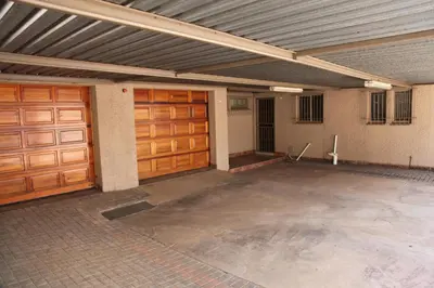 an empty garage with two wooden garage doors at Guest Home KS2E - Self Catering in Kempton Park