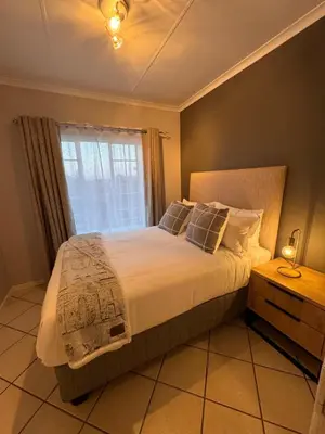 a bedroom with a large bed with a window at Centurion La Creme Apartments in Centurion