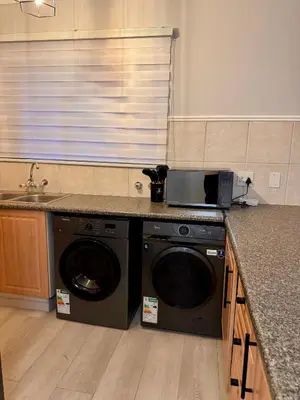 a kitchen with a washing machine and a sink at Centurion La Creme Apartments in Centurion
