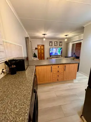 a kitchen with wooden cabinets and a counter top at Centurion La Creme Apartments in Centurion