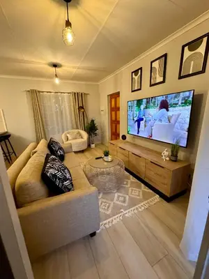 a living room with a couch and a big screen tv at Centurion La Creme Apartments in Centurion